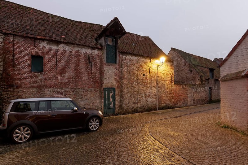 Modern Mini Clubman parked in an old village alleyway with brick buildings, twilight, Damme, West Flanders, Flanders, Belgium, Europe
