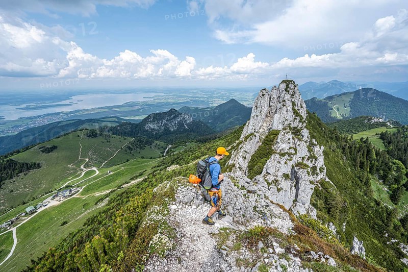 Climber on a climbing tour, on a mountain ridge, behind the summit of the Kampenwand with summit cross, alpine climbing, crossing the Kampenwand, Chiemgau, Bavaria, Germany, Europe