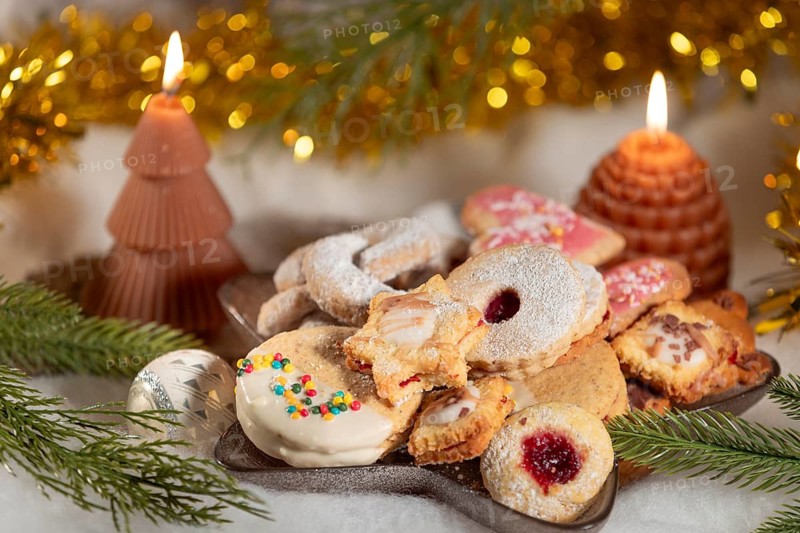A plate of festive Christmas biscuits decorated with candles and fir branches