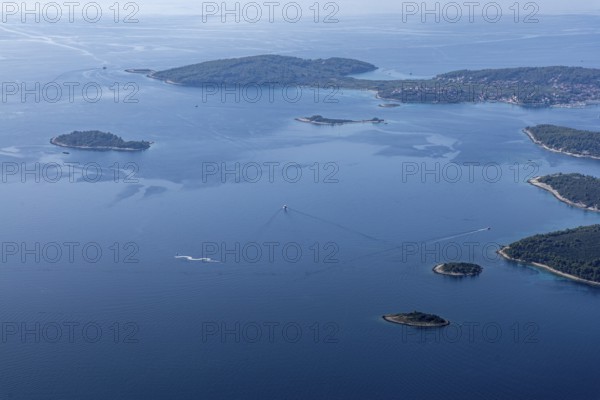 Aerial view of several small islands in the blue sea with visible boat radius, Peljesac, Croatia, Europe