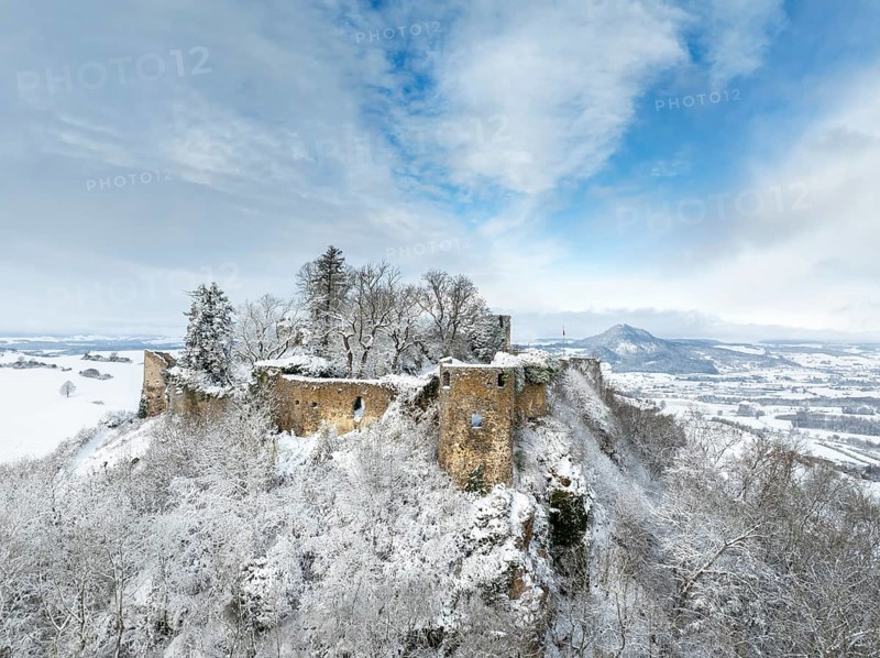 Aerial view of the snow-covered Hegau volcano Mägdeberg with remains of a castle wall on a cold winter morning, on the horizon the neighbouring Hegau volcano Hohenhewen, district of Constance, Baden-Württemberg, Germany, Europe