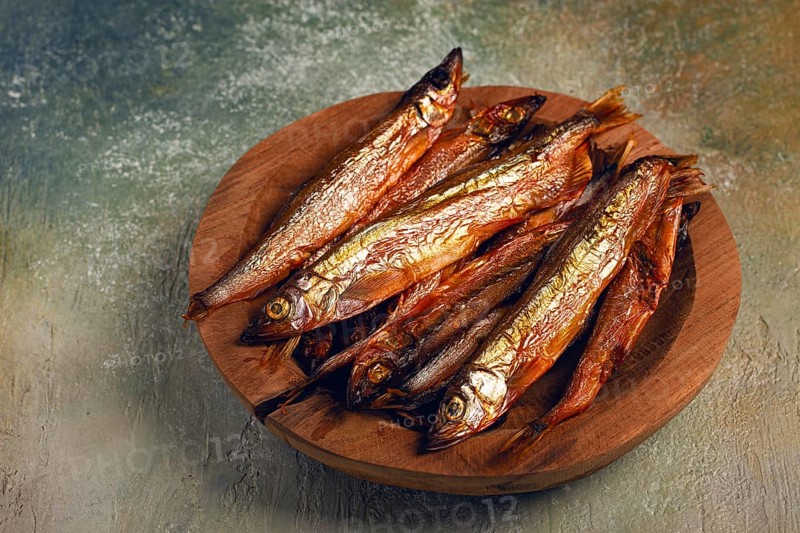 Cold smoked capelin, on a wooden bowl, top view, no people