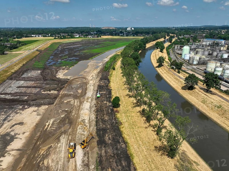 Oberhausen, North Rhine-Westphalia, Germany, renaturalisation of the Emscher in the Holtener Bruch. OQ Chemicals plant Ruhrchemie on the right. The currently straightened Emscher, shown here at flood level, has been given curves again and can meander through its new floodplain. The ecological conversion of the Emscher system consists of the construction of a centralised wastewater treatment system in the Ruhr region, the construction of sewers and the renaturation of the Emscher and its tributaries. Following the construction of a parallel sewer, the Emscher has been completely free of sewage since January 2022. The river was previously an open, above-ground combined sewer with rainwater and wastewater, Europe