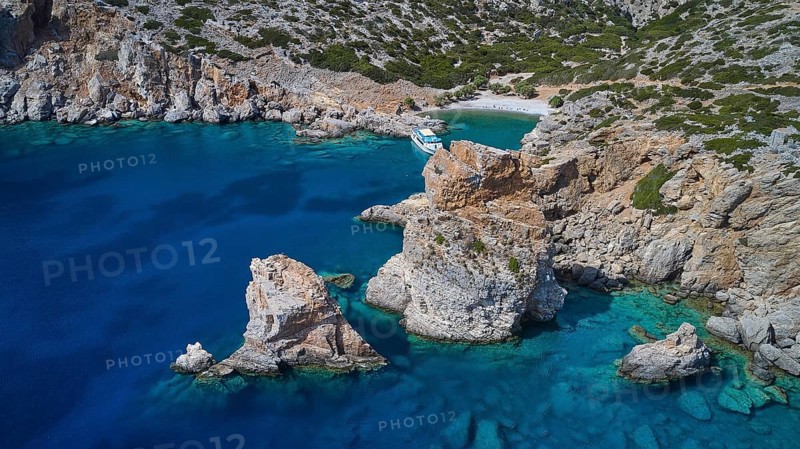 Palatia Beach, Palatia, rocks protrude from the turquoise blue sea near a boat on the rocky coast, boat tour Saria, Saria Island, Karpathos, Dodecanese, Greek Islands, Greece, Europe