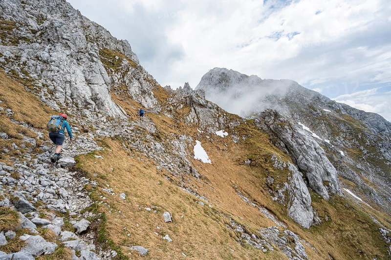 Mountaineer on a narrow hiking trail, ascent to the Maukspitze, clouds moving around the mountains, Wilder Kaiser, Kaiser Mountains, Tyrol, Austria, Europe