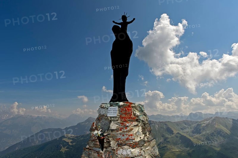 Figure of the Virgin Mary with child against the light on the summit of Mont Noble, Nax, municipality of Mont-Noble, Val d'Hérens, Valais, Switzerland, Europe