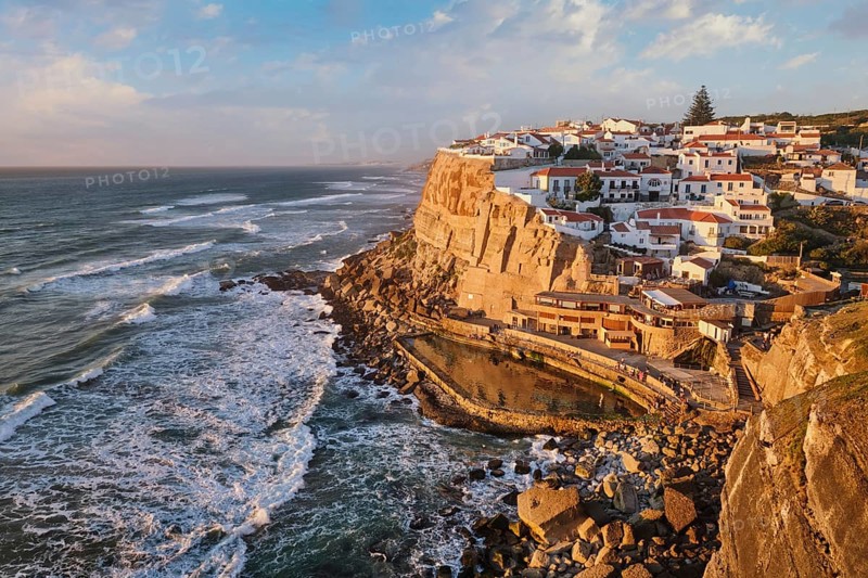 Scenic view of the seaside Azenhas do Mar fishing village on cliff on Atlantic ocean coast, Portugal on sunset
