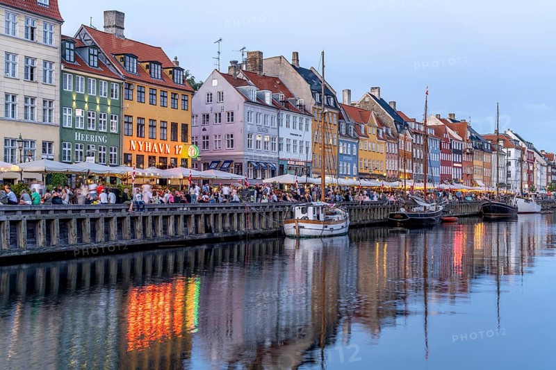 Colourful houses, restaurants and historic ships on the Nyhavn canal and harbour at dusk, Copenhagen, Denmark, Europe