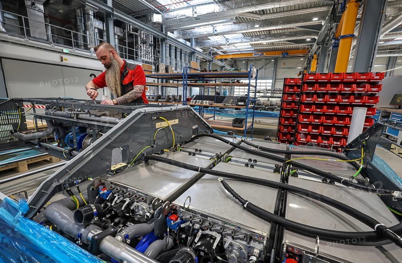 Herten, North Rhine-Westphalia, Germany, Cummins Hydrogenics fuel cell factory. An employee assembles fuel cell systems for Alstom's Coradia iLint hydrogen trains. The Coradia iLint is the world's first passenger train to be powered by a hydrogen fuel cell, which generates electrical energy for propulsion. Six fuel cell modules are installed in each train (right in the picture) . Note: The person pictured has given their verbal consent for publication in the press, Europe