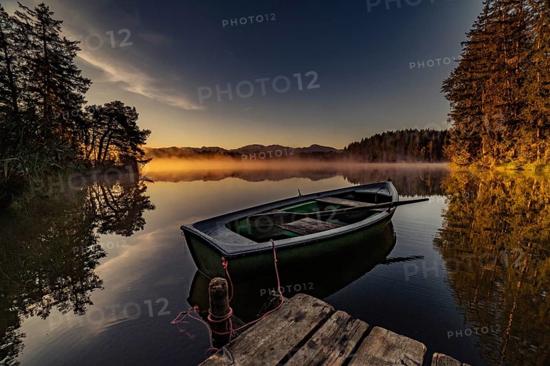 Boats in the autumnal Schmutter Weiher in the Allgäu near the municipalities of Halblech, Roßhaupten and Lechbruck in Ostallgäu in the foothills of the Alps