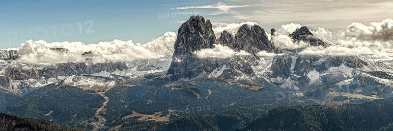 Panoramic view of the majestic mountain peaks of the Sella Group towering into the sky, surrounded by plush clouds in South Tyrol, Italy, Europe
