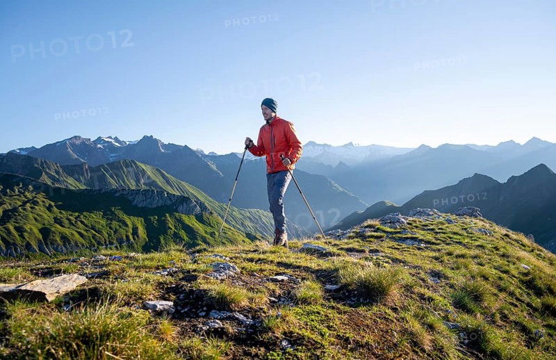 Hiker enjoying the mountain panorama in the morning, Venediger group, behind Dreiherrenkopf, Simonysitze and Großer Geiger, Hohen Tauern, Austria, Europe