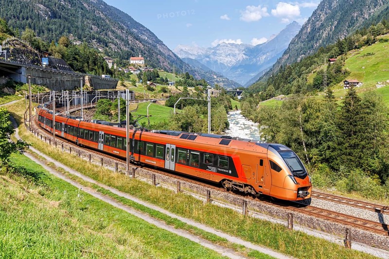 Railway passenger train of the type Stadler Flirt of the Südostbahn on the Gotthard railway in the Alps in Wassen, Switzerland, Europe