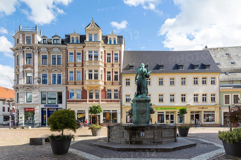 Pigeon girl on the Schlegelbrunnen with a view of the Carl Rudolph department stores' and residential and commercial buildings on the Obermarkt, Döbeln, Saxony, Germany, Europe