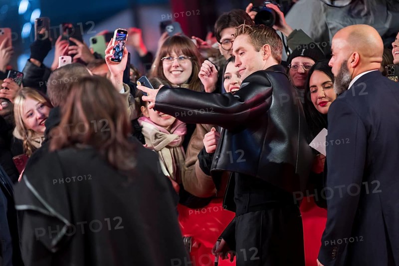 Robert Pattinson takes selfies with fans on the red carpet at the Special Gala of the film Mickey 17 at the 75th Berlinale at the Theater am Potsdamer Platz in Berlin on 15.02.2025