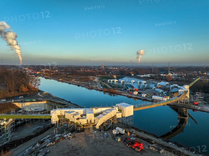 Castrop-Rauxel, North Rhine-Westphalia, Germany, new construction of a bridge -jump over the Emscher-, a pedestrian and cycle bridge over the Emscher and the Rhine-Herne Canal. EMSCHERLAND construction project, a 37-hectare water and nature adventure park at the water crossroads of the Rhine-Herne Canal and the renaturalised Emscher on the border between Recklinghausen and Castrop-Rauxel. EMSCHERLAND will also be a future garden for the International Garden Exhibition 2027. Before the renaturalisation, the Emscher river system was an open, above-ground wastewater canal, a mixed water canal with surface water and wastewater. At the back left, the Uniper power plant Datteln 4, Europe