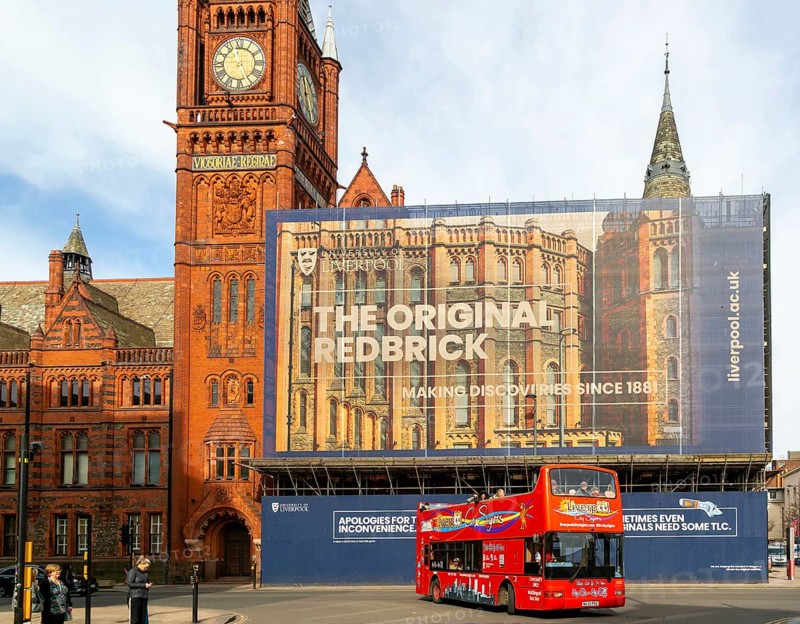 Victoria building clocktower renovation of art gallery, University of Liverpool, England, UK - red double-decker tour bus passing