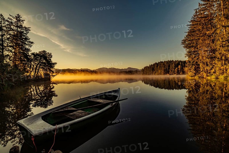 Boats in the autumnal Schmutter Weiher in the Allgäu near the municipalities of Halblech, Roßhaupten and Lechbruck in Ostallgäu in the foothills of the Alps