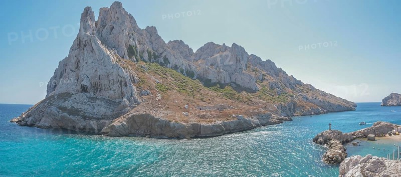A beautiful island with a rocky coastline and a blue sea. The island is surrounded by a rocky cliff and the water is calm. Les Goudes, Marseille, Provence, Côte d'Azur, France, Europe