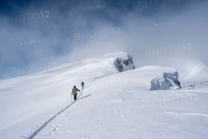 Two ski tourers in a snowy mountain landscape, ascent to the Wildhorn, cloudy mood, high tour, Bernese Alps, Bernese Oberland, Switzerland, Europe