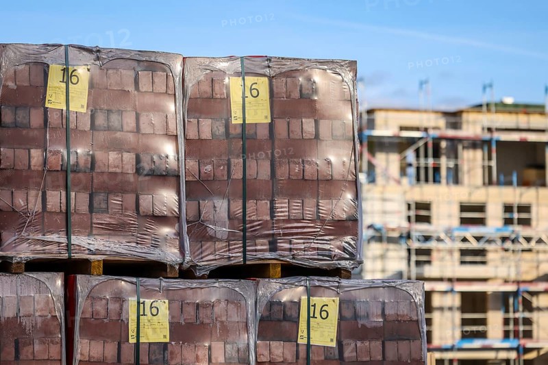 Bedburg, North Rhine-Westphalia, Germany, building material, clinker bricks packed on pallets, residential construction, new construction of multi-family residential buildings, new construction project, four-storey residential complex, one third of the flats are publicly subsidised, freely financed for rent and for purchase as condominiums, Europe
