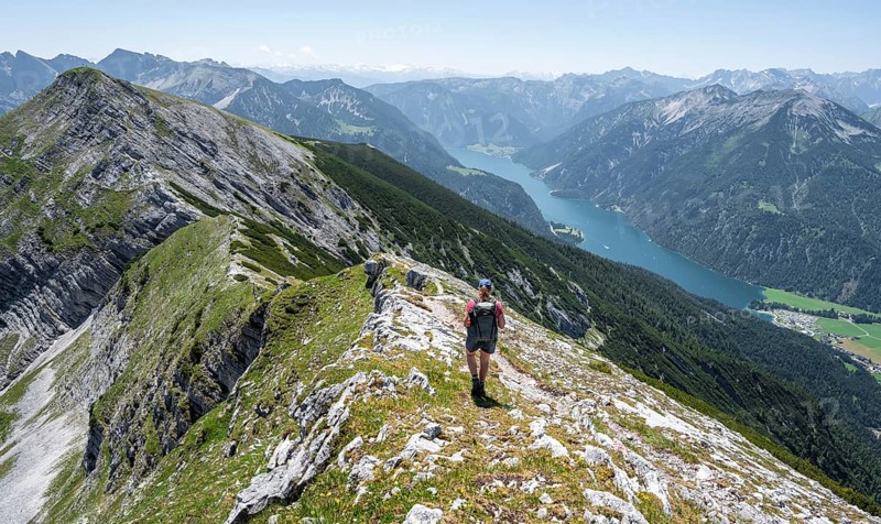 Mountaineer on the summit ridge of the Unnütz, behind Achensee and summit of the Seekarspitze Unnütz crossing, Brandenberg Alps, Tyrol, Austria, Europe