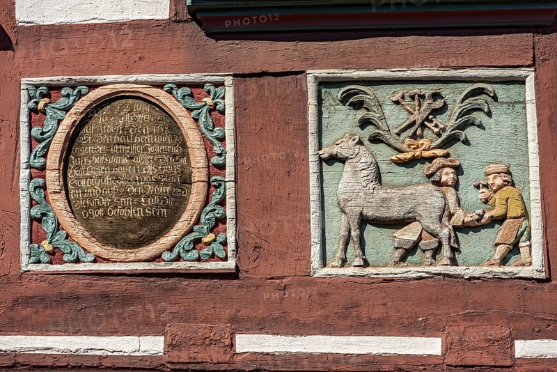 Colourful painted carvings, medallion with inscription, relief for blacksmith Johenrich Jung on the half-timbered house Gasthaus Zum Goldenen Löwen, market square, historic old town, Butzbach, Wetterau, Hesse, Germany, Europe