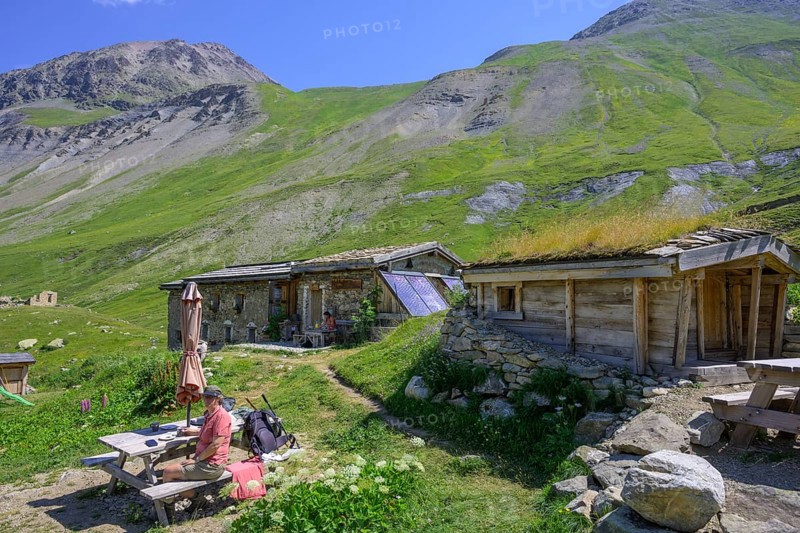 Woman enjoying a coffee break at the Chalet refuge de Chamoissiére, Villar-d'Arêne, Département Hautes-Alpes, France, Europe