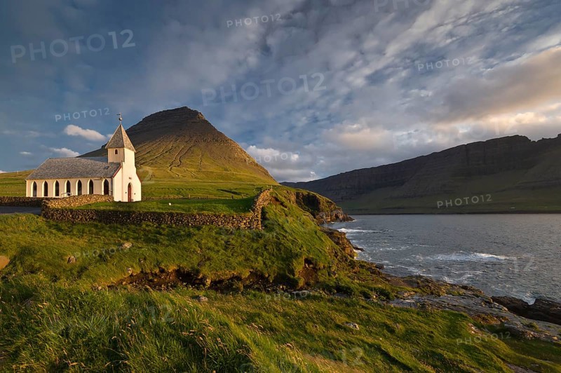 Church in the evening light surrounded by mountains, sea, Vidareidi, Vidoy Island, Viðareiði, Viðoy Island, Faroe Islands, Denmark, Europe