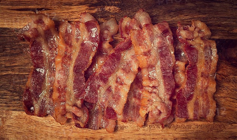 Fried bacon on a cutting board, top view, close-up, homemade, breakfast, no people