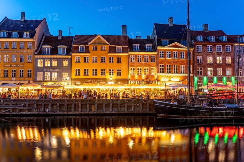 Colourful houses, restaurants and historic ships on the Nyhavn canal and harbour at dusk, Copenhagen, Denmark, Europe