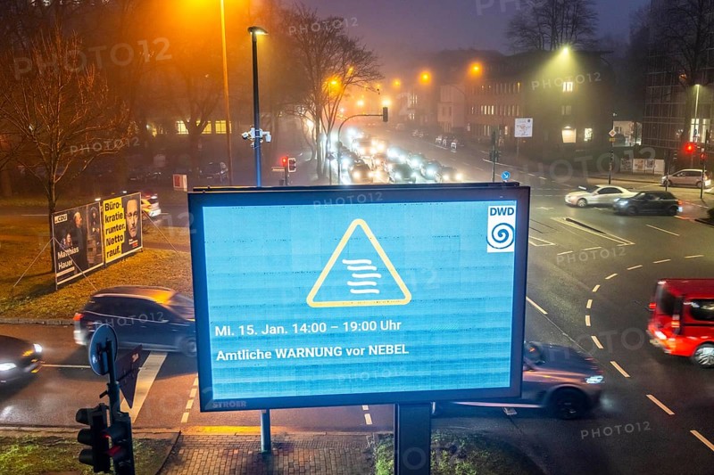 Dense fog, with visibility partly below 100 metres, city centre traffic at rush hour on Alfredstraße, B224, official warning of fog, digital billboard, advertising board, in Essen, North Rhine-Westphalia, Germany, Europe