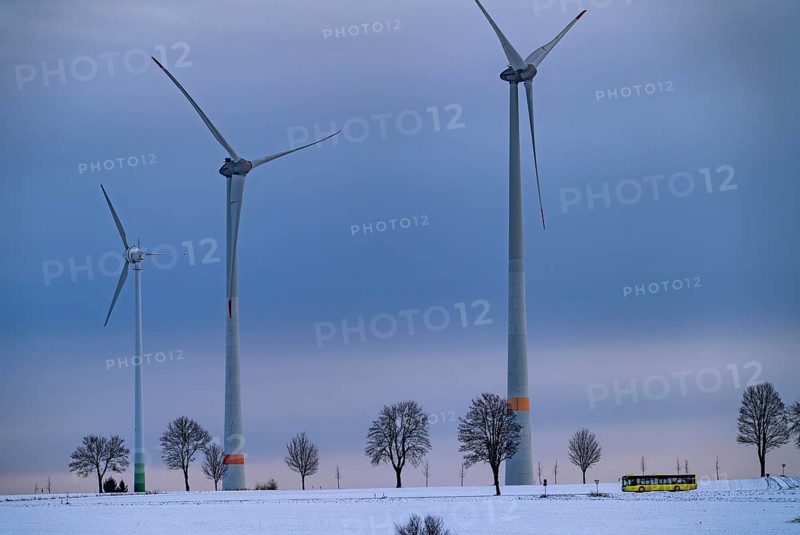 Country road, local train, wind farm, north of Lichtenau, self-proclaimed energy town, over 190 wind turbines and over 1200 solar panels generate 10 times as much electricity as the community of 11, 900 inhabitants consumes, largest onshore cluster of wind turbines in Germany, winter, slightly snow-covered landscape, North Rhine-Westphalia, Germany, Europe