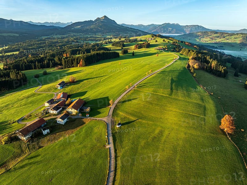Mountain range near village Wertach, view to mt. Gruenten, sunrise, fog in valley, traditional farm, autumn colors, aerial view, Allgaeu, Bavaria, Germany, Europe