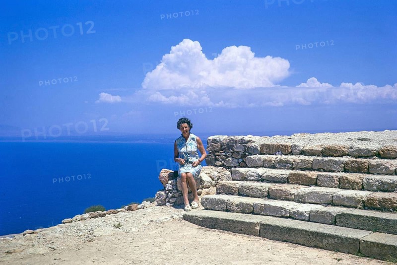 Woman tourist sitting on stone wall at Roman ruins of Vouni Palace, Lefke, Northern Cyprus, Europe 1973