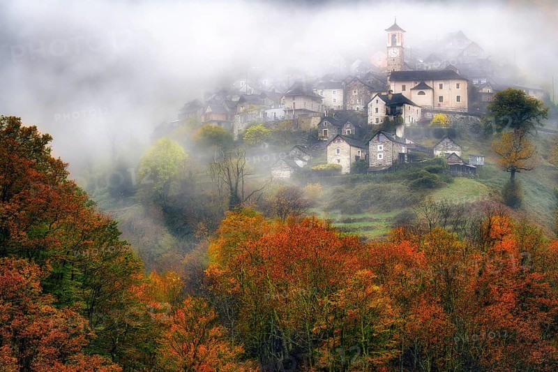 Village view of Corippo in the fog surrounded by autumn-coloured deciduous trees, Verzasca Valley, Canton Ticino, Switzerland, Europe
