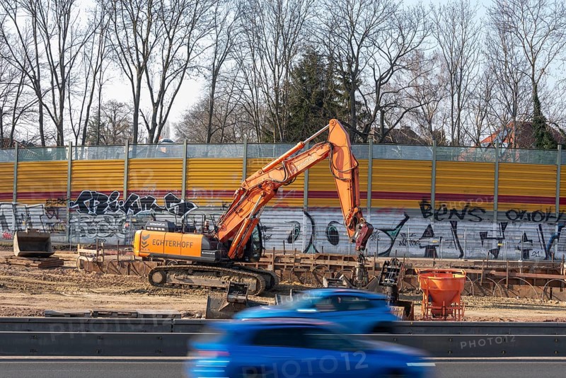 Excavator working on a construction site next to a graffiti-covered wall, Magdeburg, Saxony-Anhalt, Germany, Europe