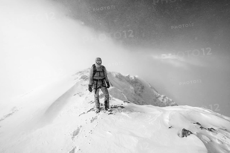 Ski tourer in snowy mountain landscape, at the summit of the Wildhorn, cloudy mood, high tour, black and white photo, Bernese Alps, Bernese Oberland, Switzerland, Europe