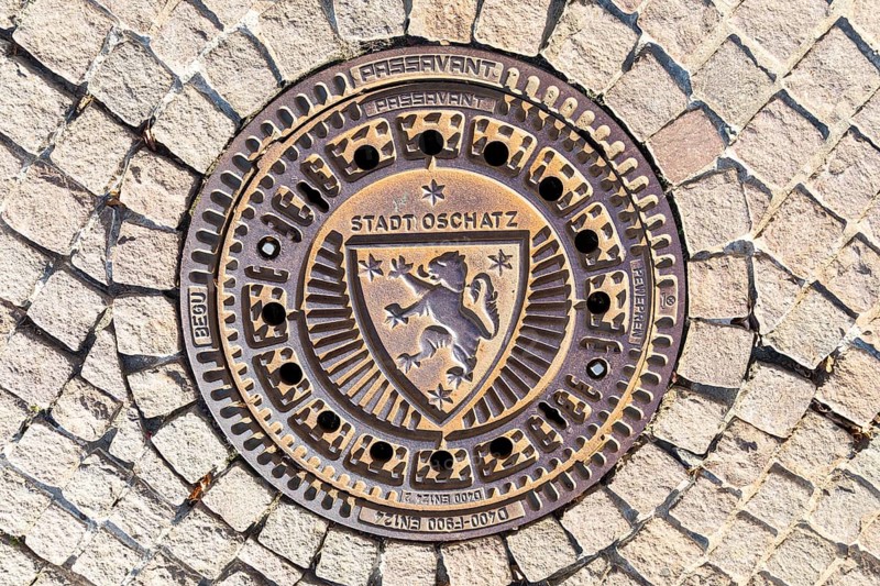 Manhole cover with the coat of arms of the town of Oschatz, Saxony, Germany, Europe
