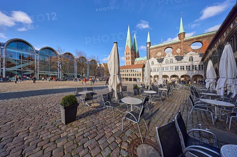 Church tower of St. Marien zu Lübeck, outdoor area of Café Niederegger - arcade café with tables, chairs and parasols, modern architecture with a branch of the fashion chain Peek & Cloppenburg, cobblestone square, market square, Hanseatic city of Lübeck, independent city, Schleswig-Holstein, Germany, Europe
