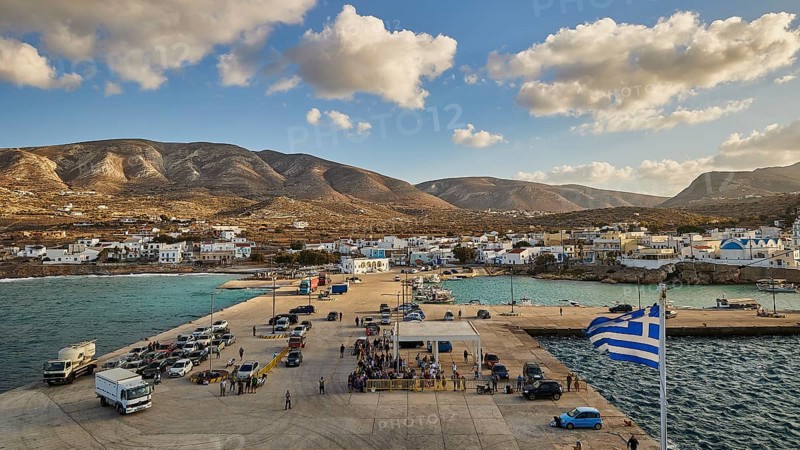 Coastal view of a harbour with a small village and mountains in the background under a blue sky with clouds, Kassos Island, neighbouring island Karpathos, Dodecanese, Greek Islands, Greece, Europe