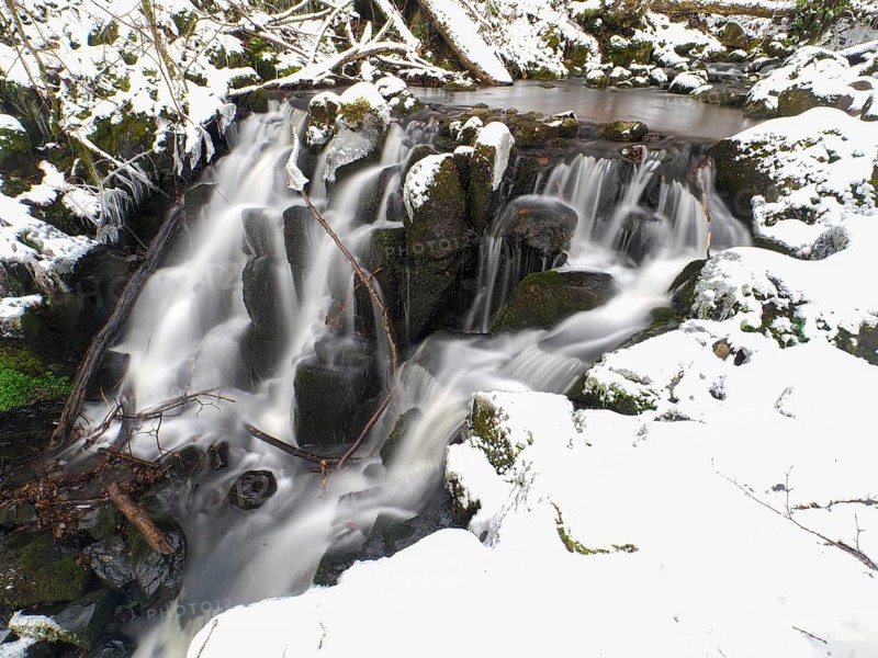 Teufelsmühle waterfall on the hill stream the Schwartzbach, in snow and ice in November. The Rhön UNESCO Biosphere nature reserve, county Bavaria, Germany, Europe