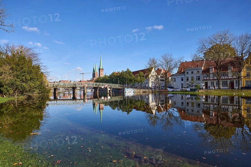 River Trave at high water, general architecture, pedestrian bridge, trees and bushes, reflections on the water surface, blue sky with fair weather clouds, Hanseatic city of Lübeck, independent city, Schleswig-Holstein, Germany, Europe