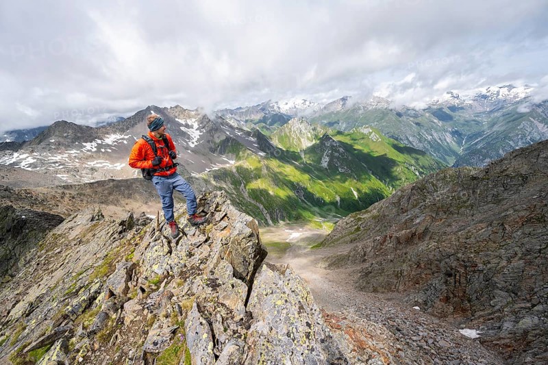 Mountaineer on a steep rocky ridge, at the summit of Lasörling, view of mountains of the Venediger group, Lasörling group, Hohe Tauern National Park, East Tyrol, Tyrol, Austria, Europe