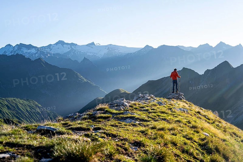 Hiker enjoying the mountain panorama in the morning, Venediger group, behind Dreiherrenkopf, Simonysitze and Großer Geiger, Hohen Tauern, Austria, Europe