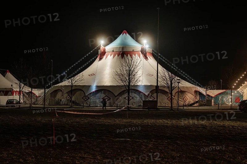 Standard illuminated circus tent at night with bare trees, Böblingen, Germany, Europe