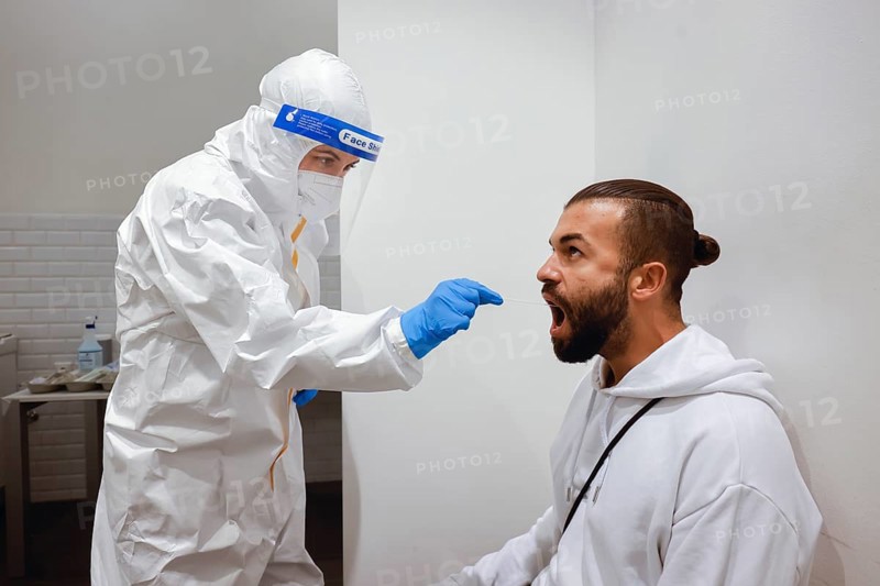 Cologne, North Rhine-Westphalia, Germany - Covid rapid test at the Medicare test centre, throat swab on cotton swab (posed scene)