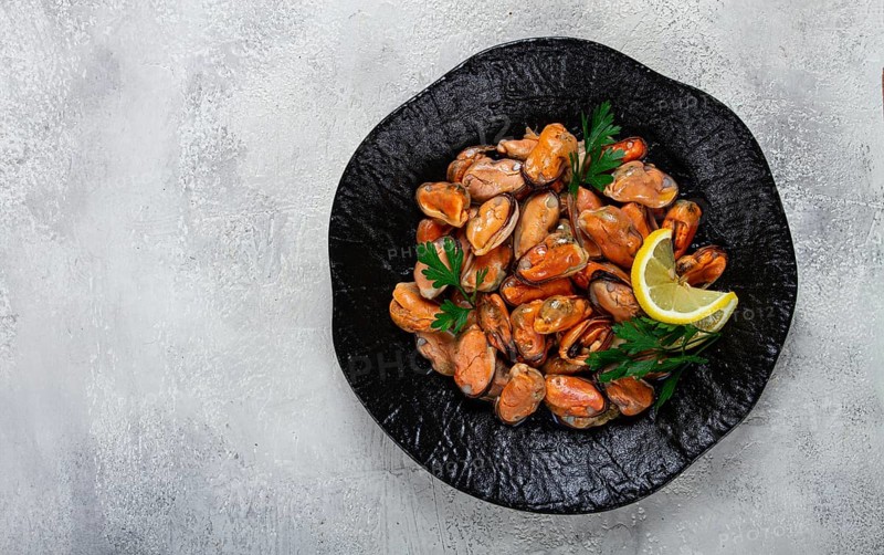 Mussels no shell, boiled, mussels, peeled, in a bowl, with lemon and parsley, Chilean mussels, top view, no people