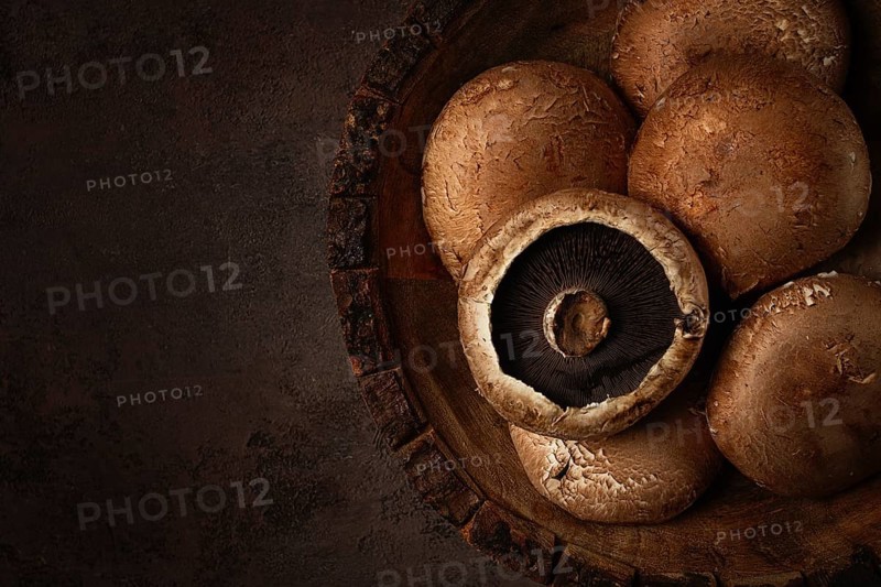 Fresh Portobello mushrooms, in a wooden bowl, top view, close-up, no people