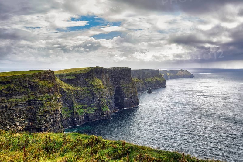 Cliffs of Moher in the haze, rain clouds on the horizon, Ireland, Europe